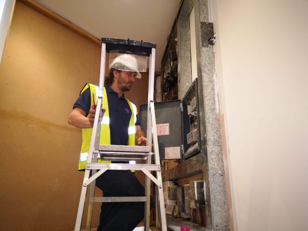 Electrician performing general electrical installations including lighting and power systems.