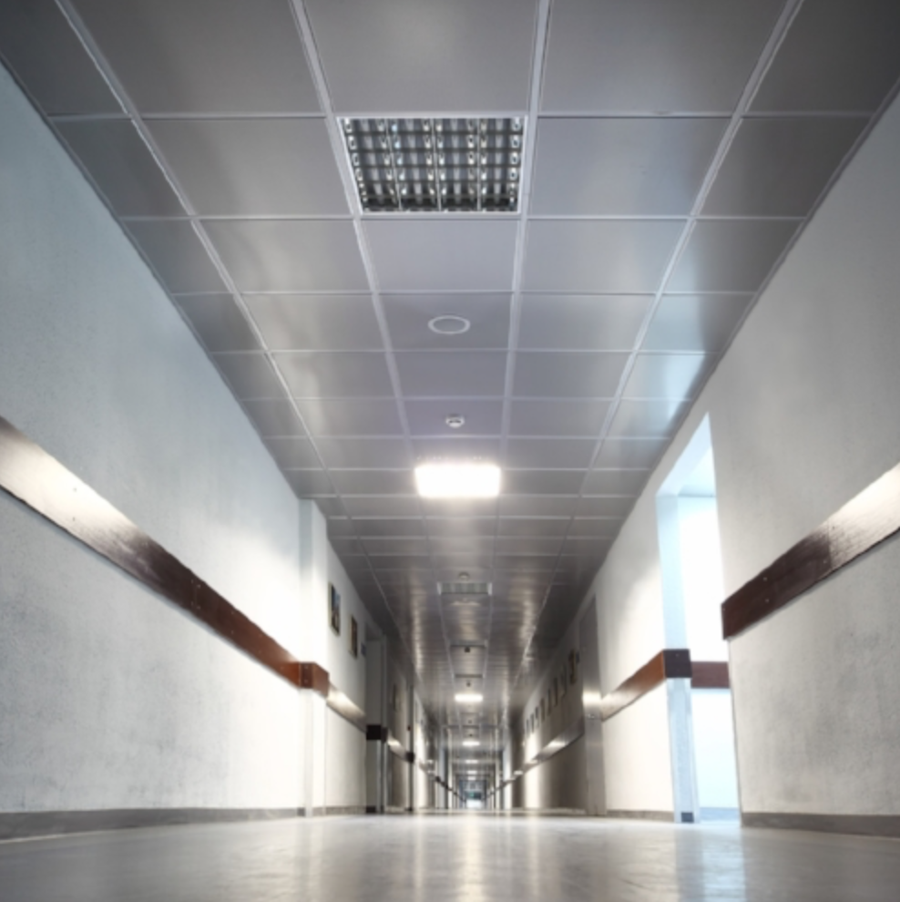 Installation of emergency lighting in a hallway, providing safe exit routes in case of emergencies.