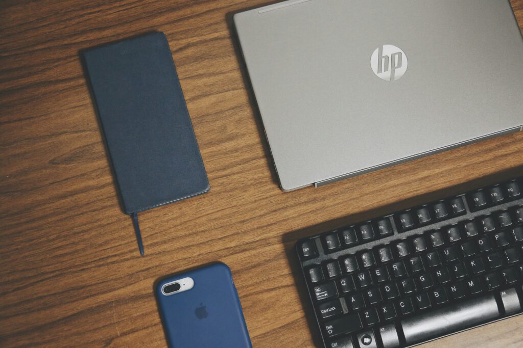  Birdseye view of a laptop keyboard and various mobile phones, emphasizing the process of refurbishing IT equipment