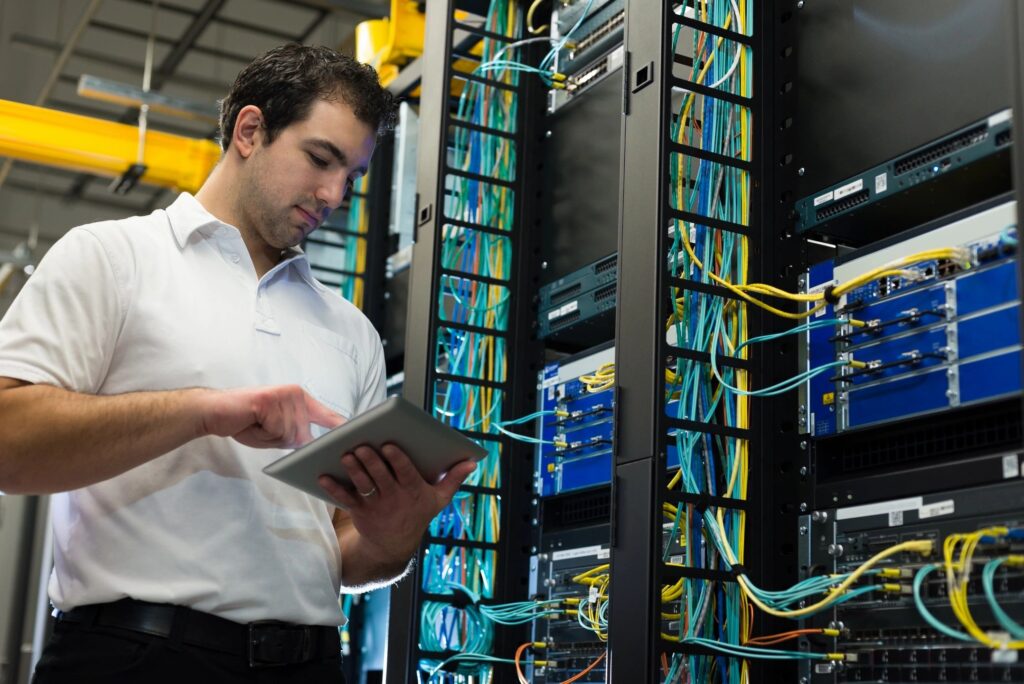  A neatly organized network cabling setup with color-coordinated cables and properly mounted patch panels in a communications room.