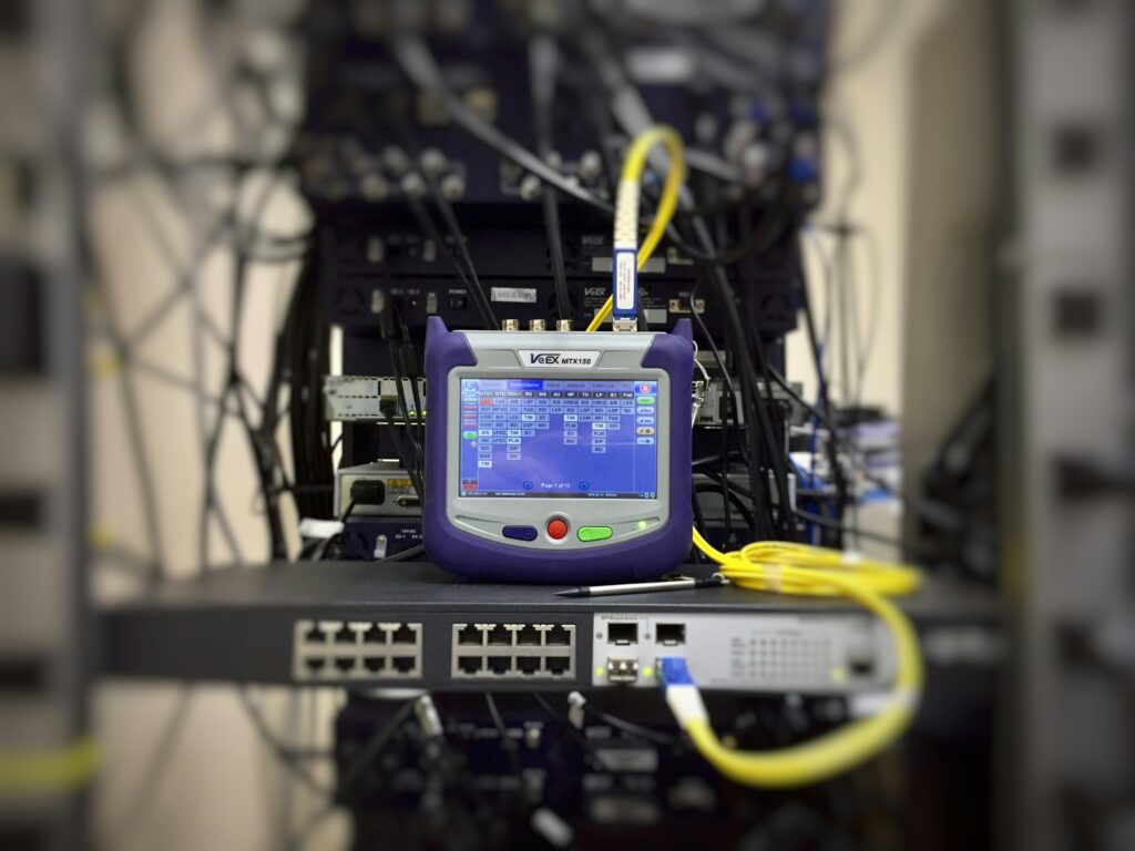 A telecommunication test set connected to a network switch, to perform some data transmission quality measurements. (I’ve been looking for photography I can use for my technical training materials, but there is usually none, so I’m starting to add some for others who may also be looking.)