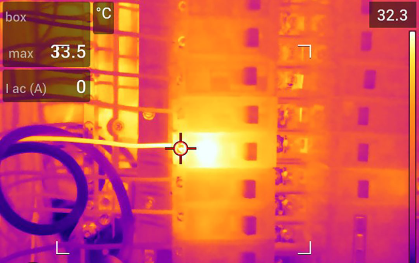 Thermal imaging camera detecting heat patterns in electrical components.